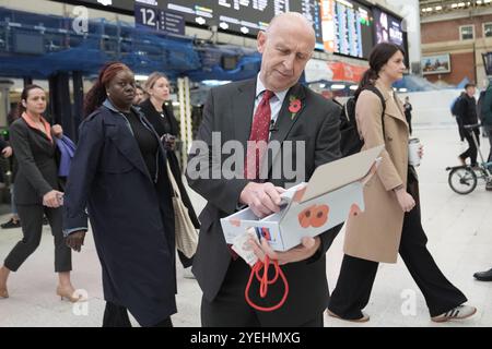 Le secrétaire à la Défense John Healey se joint au personnel militaire en service pour distribuer des coquelicots et recueillir des dons pour l’appel de la Royal British Legion à Victoria Station, lors de la fête du coquelicot à Londres. Date de la photo : jeudi 31 octobre 2024. Banque D'Images