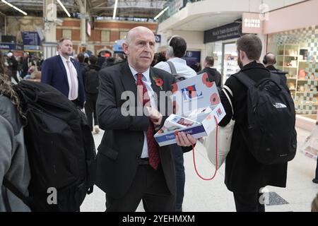 Le secrétaire à la Défense John Healey se joint au personnel militaire en service pour distribuer des coquelicots et recueillir des dons pour l’appel de la Royal British Legion à Victoria Station, lors de la fête du coquelicot à Londres. Date de la photo : jeudi 31 octobre 2024. Banque D'Images