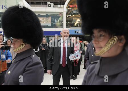 Le secrétaire à la Défense John Healey se joint au personnel militaire en service pour distribuer des coquelicots et recueillir des dons pour l’appel de la Royal British Legion à Victoria Station, lors de la fête du coquelicot à Londres. Date de la photo : jeudi 31 octobre 2024. Banque D'Images