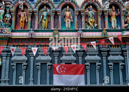 Vue extérieure du temple Sri Krishnan (hindou) à Waterloo Street, Bugis, Singapour, avec des statues colorées de divinités hindoues et un drapeau singapourien Banque D'Images