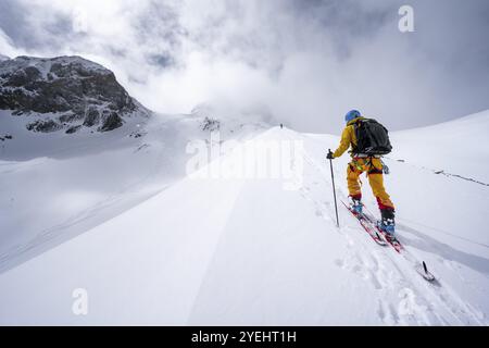 Randonneurs de ski dans un paysage de montagne enneigé, ascension vers le Wildhorn, ambiance nuageuse, haute randonnée, Alpes bernoises, Oberland bernois, Suisse, Europe Banque D'Images