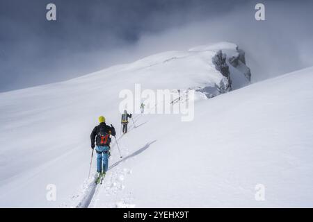 Trois randonneurs de ski dans un paysage de montagne enneigé, ascension vers le Wildhorn, ambiance nuageuse, haute randonnée, Alpes bernoises, Oberland bernois, Suisse, Europe Banque D'Images