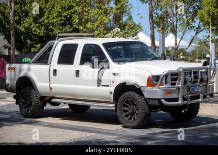 Un véhicule utilitaire Ford F250XLT 4x4 blanc avec pare-buffle, garé à l'extérieur dans une zone urbaine ombragée. Banque D'Images