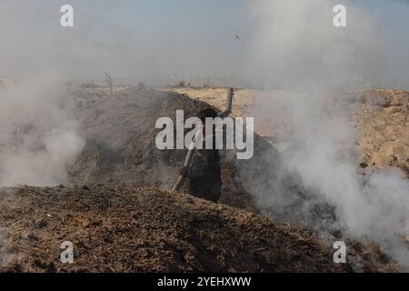 Des travailleurs palestiniens râtelent du bois brûlé sur un site de production de charbon de bois à Khan Yunis dans le Sud de la bande de Gaza des travailleurs palestiniens râtelent du bois brûlé sur un site de production de charbon de bois à Khan Yunis dans le Sud de la bande de Gaza le 30 octobre 2024 dans le cadre de la guerre en cours dans le territoire palestinien entre Israël et le Hamas. Photo de Omar Ashtawy apaimages Khan Yunis bande de Gaza territoire palestinien 311024 KhanYunis OSH 008 Copyright : xapaimagesxOmarxAshtawyxxapaimagesx Banque D'Images