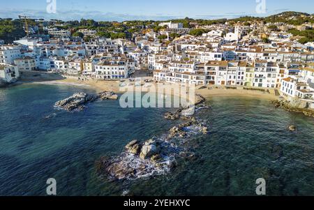 Vue aérienne d'une ville côtière pittoresque avec des bâtiments blancs, plage de sable et mer bleue claire sous un ciel ensoleillé, Calella de Plafrugell ville, Costa B. Banque D'Images