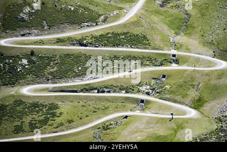 Vue aérienne d'une route sinueuse traversant des collines verdoyantes par une journée ensoleillée Banque D'Images