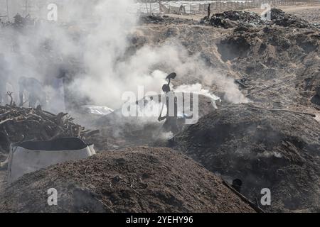 Des travailleurs palestiniens râtelent du bois brûlé sur un site de production de charbon de bois à Khan Yunis dans le Sud de la bande de Gaza des travailleurs palestiniens râtelent du bois brûlé sur un site de production de charbon de bois à Khan Yunis dans le Sud de la bande de Gaza le 30 octobre 2024 dans le cadre de la guerre en cours dans le territoire palestinien entre Israël et le Hamas. Photo de Omar Ashtawy apaimages Khan Yunis bande de Gaza territoire palestinien 311024 KhanYunis OSH 0017 Copyright : xapaimagesxOmarxAshtawyxxapaimagesx Banque D'Images