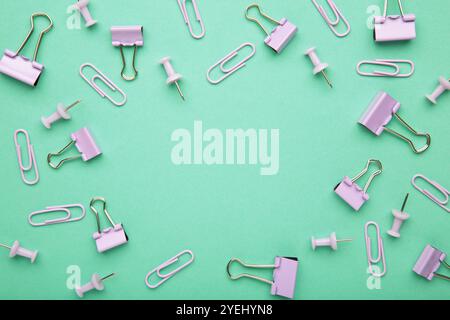 Ensemble de trombones violets, de classeurs et d'épingles sur fond de menthe. Vue de dessus Banque D'Images