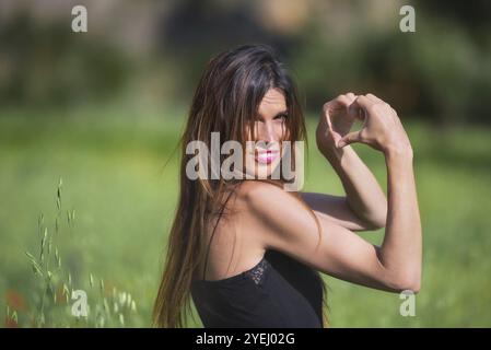 Belle femme souriante. Symbole en forme de coeur. Concept d'amour et de nature. Écologie et durabilité Banque D'Images