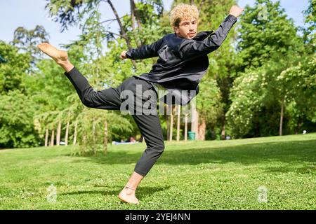 jeune homme sautant et dansant ballet contemporain dans le parc avec costume urbain. Banque D'Images