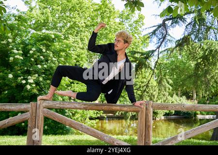 jeune homme sautant et dansant ballet contemporain dans le parc avec costume urbain. Banque D'Images