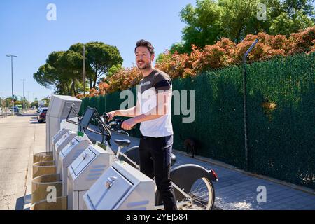 Jeune étudiant attrayant loue vélo Banque D'Images