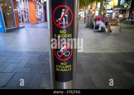 Gros plan d'un poteau dans un centre commercial affichant des panneaux interdisant les cyclistes et les cyclistes. Banque D'Images