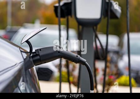 Un véhicule électrique se recharge à une station pendant que son propriétaire est au travail, permettant une batterie complètement chargée au moment où il revient. Cette configuration maximi Banque D'Images