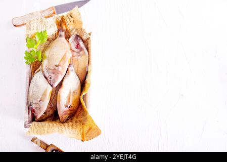 Poisson cru sur papier sur une table. Ils semblent frais et prêts à cuire. Banque D'Images