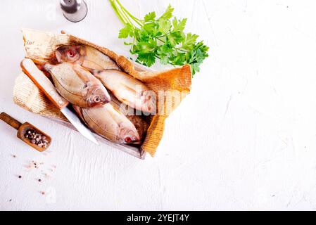 Poisson cru sur papier sur une table. Ils semblent frais et prêts à cuire. Banque D'Images