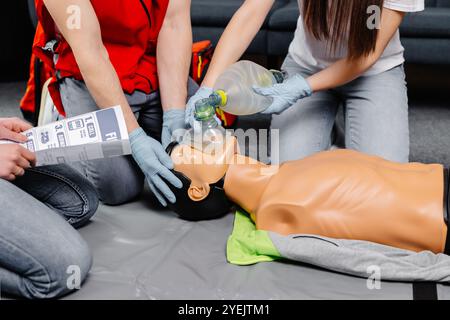 Femme tenant un sac respiratoire poche Ambu.démonstration de la RCP formation à la réanimation cardio-pulmonaire procédure médicale sur la poupée de la RCP dans la classe.Comm. Paramédic Banque D'Images