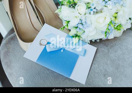 Accessoires de la mariée. Chaussures de mariage pour la mariée. Chaussures blanches à talons hauts près des anneaux de mariage, bijoux de mariage. Banque D'Images