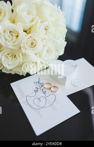 Accessoires de la mariée. Chaussures de mariage pour la mariée. Chaussures blanches à talons hauts près des anneaux de mariage, bijoux de mariage. Banque D'Images