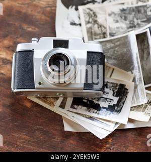 Bureau en bois, vintage et appareil photo avec des photographies vintage en noir et blanc. Numérique, old School et table avec des images pour la créativité, le projet et Banque D'Images