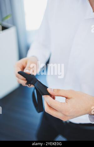 Un homme tient un papillon vert élégant dans ses mains. Noeud papillon pour un look élégant. Banque D'Images