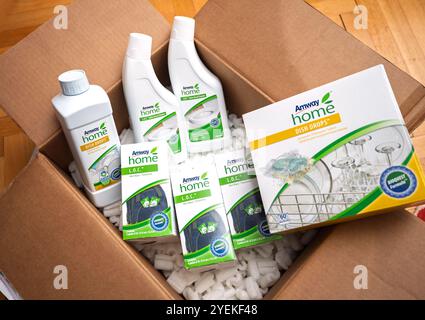 Paris, France - 26 mars 2020 : boîte ouverte avec divers produits de nettoyage Amway Home, y compris des gouttes à vaisselle, des nettoyants polyvalents L.O.C. et des mini lingettes, entourées d'arachides emballées sur un plancher de bois franc Banque D'Images