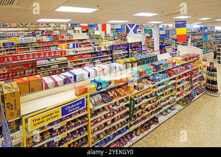 Vue intérieure tablette supérieure surstockez la marchandise dans un emballage en carton au-dessus des étagères des allées de shopping dans un grand supermarché alimentaire Londres Angleterre Royaume-Uni Banque D'Images