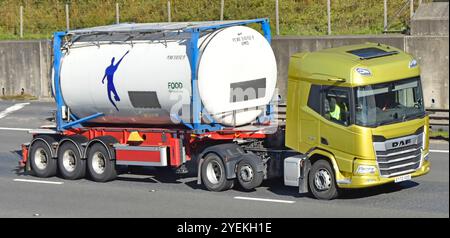 Jaune DAF marque hgv camion de moteur principal remorque squelettique avec cylindre de réservoir de conteneur alimentaire intermodal conduisant la route autoroute M25 Angleterre Royaume-Uni Banque D'Images