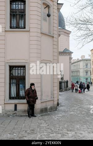 Lviv, Ukraine, 8 janvier 2015 : homme adulte âgé sans abri avec une longue barbe blanche et des vêtements pauvres demandant de l'argent aux gens debout sur la ville s Banque D'Images