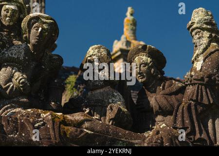 Détail de la scène de la tombe du Christ sculptée fin des années 1500 sur un calvaire dans la paroisse proche de l'Eglise Saint-Miliau dans le village de Guimiliau, Finistère, Bretagne, France. Les figures sont toutes en robe du 16ème siècle. Banque D'Images