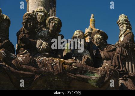 Détail de la scène de la tombe du Christ, sculptée fin des années 1500 sur calvaire dans la paroisse proche de l'Eglise Saint-Miliau dans le village de Guimiliau, Finistère, Bretagne, France. En haut à gauche se trouve la Vierge Marie accompagnée de deux femmes, dont l'une est Marie Madeleine avec un pot de parfum ou un pot de pommade. Les figures sont toutes en robe du 16ème siècle. Banque D'Images