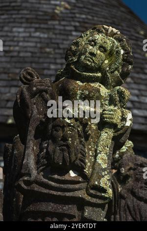 Veronica et la Sainte face de Jésus. Détail de sculpture de la fin des années 1500 sur le niveau supérieur de la face sud du calvaire dans la paroisse proche de l'Eglise Saint-Miliau dans le village de Guimiliau, Finistère, Bretagne, France. L’histoire de Véronique est contestée et n’est pas mentionnée dans les Évangiles ; selon la légende, elle a rencontré Christ portant sa croix au Golgotha, lui a donné un tissu pour essuyer son front et, après que Christ eut pressé le tissu sur son visage, a reçu le tissu imprimé à l’image du Christ. Banque D'Images