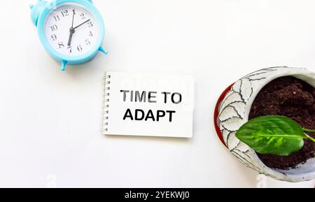 Le temps d'adaptation est écrit sur un bloc-notes sur fond blanc. Le symbole conceptuel est « le temps de l'adaptation ». Un emplacement à copier. Banque D'Images