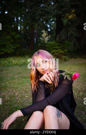 Fille avec les cheveux colorés pose avec une rose à Mt. Parc Tabor à Portland, OREGON. Banque D'Images