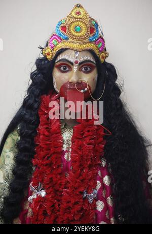 Kolkata, Inde. 31 octobre 2024. Un artiste s'habille comme la déesse hindoue Kali et attend avant une représentation à l'intérieur d'un ''pandal'' (une plate-forme temporaire), une structure décorée, à l'occasion du festival Kali Puja à Kolkata, en Inde, le 31 octobre 2024. Kali est une déesse hindoue qui représente les forces opposées de la création et de la destruction, de la mort et de la renaissance, et du temps. (Photo de Rupak de Chowdhuri/NurPhoto) crédit : NurPhoto SRL/Alamy Live News Banque D'Images