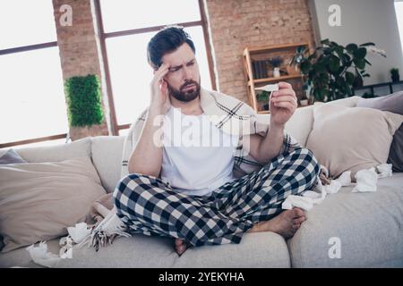 Photo d'un jeune malade malade portant un pyjama se sentant malsain symptôme de température élevée à l'intérieur Banque D'Images