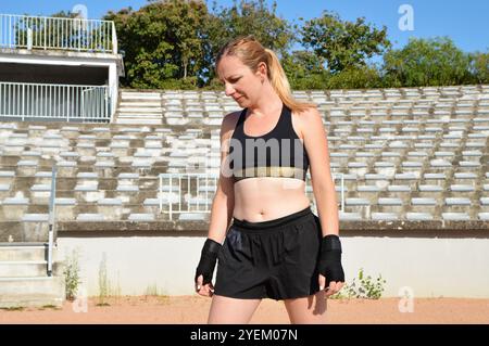 Un boxeur femme blonde ajusté pendant l'entraînement de boxe. Banque D'Images