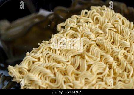 nouilles jaunes sèches pendant la cuisson, détails des nouilles de farine avec des œufs pendant la cuisson Banque D'Images