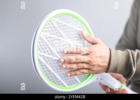 L'homme tient la tapette et touche son circuit, si elle constitue un danger physique pour le corps humain. Concept explore si une personne peut toucher Banque D'Images