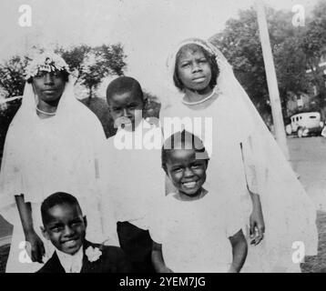 Des enfants afro-américains posent pour des photos après une cérémonie catholique de la première communion, vers 1932. Banque D'Images