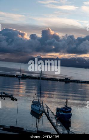 Automne lever le soleil sur la distance des montagnes enneigées et le Vagsfjorden avec un port animé et le port dans la petite ville de Harstad en Norvège, SCA Banque D'Images