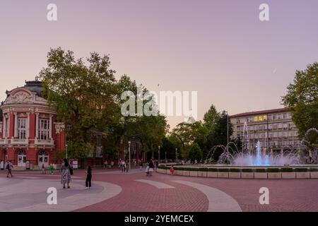 Varna, Bulgarie - 22 septembre 2023 : coucher de soleil sur la place de l'indépendance et la fontaine, avec les habitants et les visiteurs, Varna, Bulgarie Banque D'Images