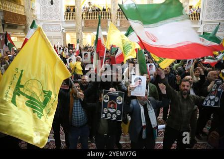 Téhéran, Iran. 31 octobre 2024. Les Iraniens brandissent les drapeaux de l'Iran et du Hezbollah lors d'une cérémonie sur la place Palestine à Téhéran, commémorant feu Hashem Safieddine, un religieux éminent qui devait succéder au dirigeant assassiné du Hezbollah Hassan Nasrallah, tué par une frappe aérienne israélienne à Beyrouth. Le porte-parole de Tsahal Daniel Hagari a confirmé le 26 octobre 2024 que des frappes précises sur des cibles militaires en Iran avaient été menées. Cependant, selon la Force de défense aérienne iranienne, l'attaque a été interceptée avec succès par le système de défense intégré iranien. (Crédit image : © Rouzbeh Fouladi/ZUM Banque D'Images