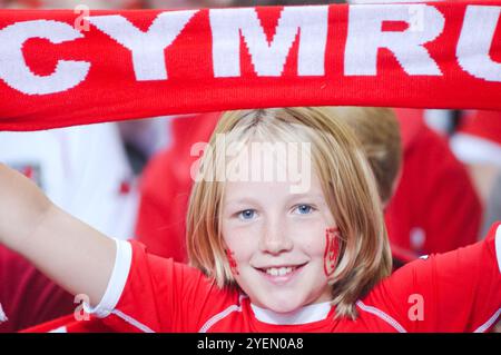 Une jeune fille avec Wales facepaint est une fan galloise passionnée dans un kit de réplique du pays de Galles et tient son écharpe galloise 'Cymru'. Match de qualification PAYS DE GALLES contre FINLANDE dans le Groupe 9 pour les 2004 euros au Millennium Stadium de Cardiff, pays de Galles, Royaume-Uni, le 10 septembre 2003. Photographie : ROB WATKINS. INFO : la campagne de qualification du pays de Galles pour le Championnat d'Europe de l'UEFA 2004 a été mémorable mais finalement déchirante. Mené par le manager Mark Hughes et avec des stars comme Ryan Giggs, ils atteignent la phase des séries éliminatoires mais manquent de peu la qualification, perdant face à la Russie malgré de bonnes performances. Banque D'Images