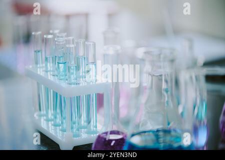 Tubes à essai de laboratoire assortis contenant divers liquides colorés sur table dans un cadre scientifique, suggérant l'expérimentation scientifique et le travail de recherche Banque D'Images