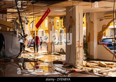 Benetusser, Valence, Espagne. 31 octobre 2024 - après les inondations, un magasin de fournitures apparaît avec ses murs effondrés et une voiture à l'intérieur. Panneau : outils Banque D'Images