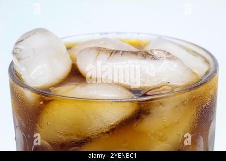 Gros plan de verre froid de boisson gazeuse avec de la glace, isolé Banque D'Images