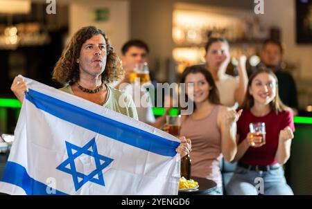 Groupe de fans dans le bar avec le drapeau israélien Banque D'Images