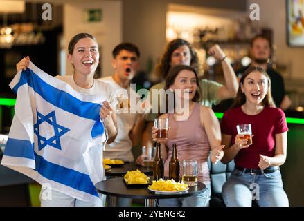 Groupe de fans dans le bar avec le drapeau israélien Banque D'Images