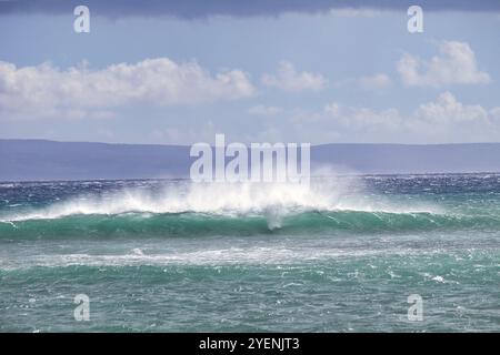 Whiote ludique coiffe sur les vagues qui s'écrasent Banque D'Images